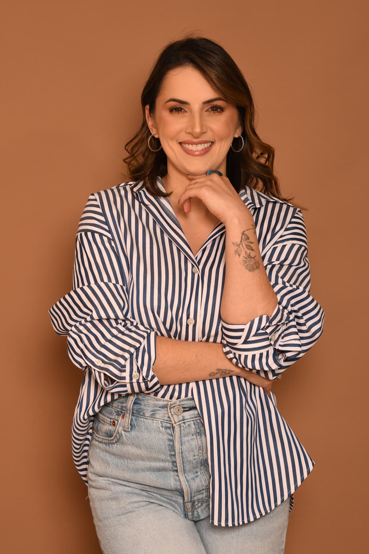 Joana Stecanella Savi sorrindo com camisa listrada azul e branca